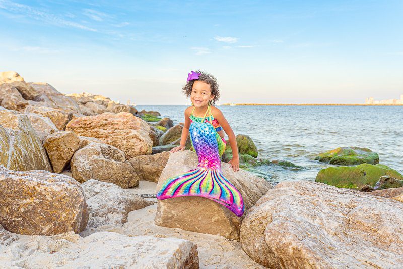 Remy the mermaid! A child dressed as a mermaid, smiling at the camera during a photographers mermaid session in Orange Beach.