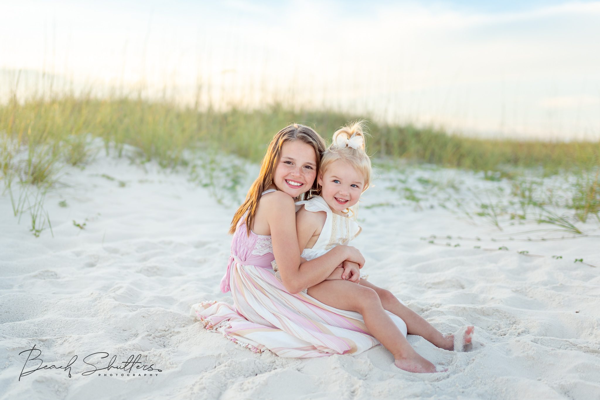 Sisters posing for coastal Orange Beach photos.